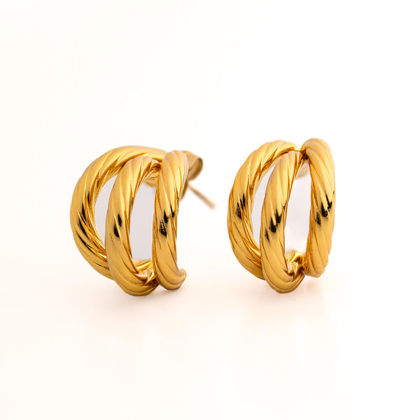 Gold hoop earrings on a light beige background