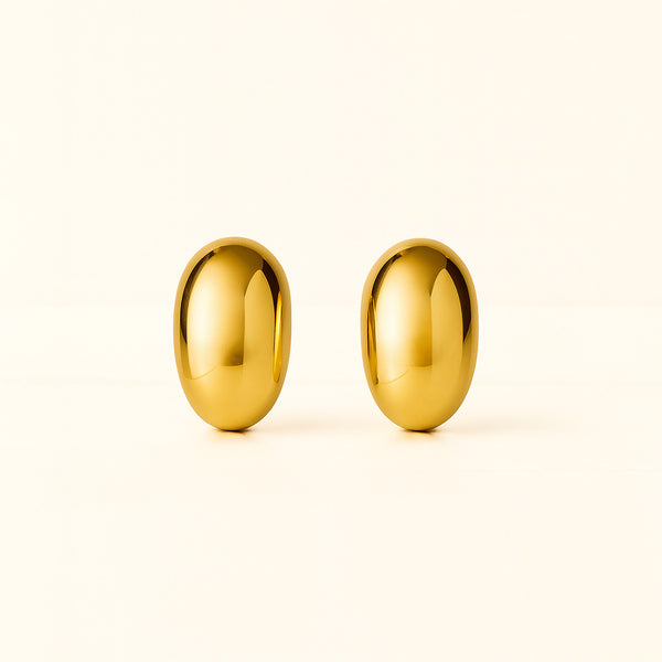 Pair of gold earrings on a light beige background