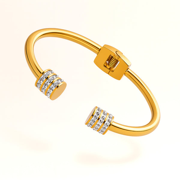 Gold bracelet with diamond accents on a light beige background